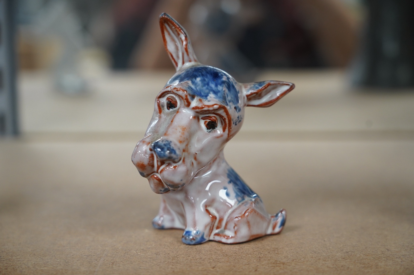 An unusual early Goebel tin glazed terracotta grotesque dog, in the style of Ida Meisinger, impressed no. KT.626., 10.5cm. Condition - good